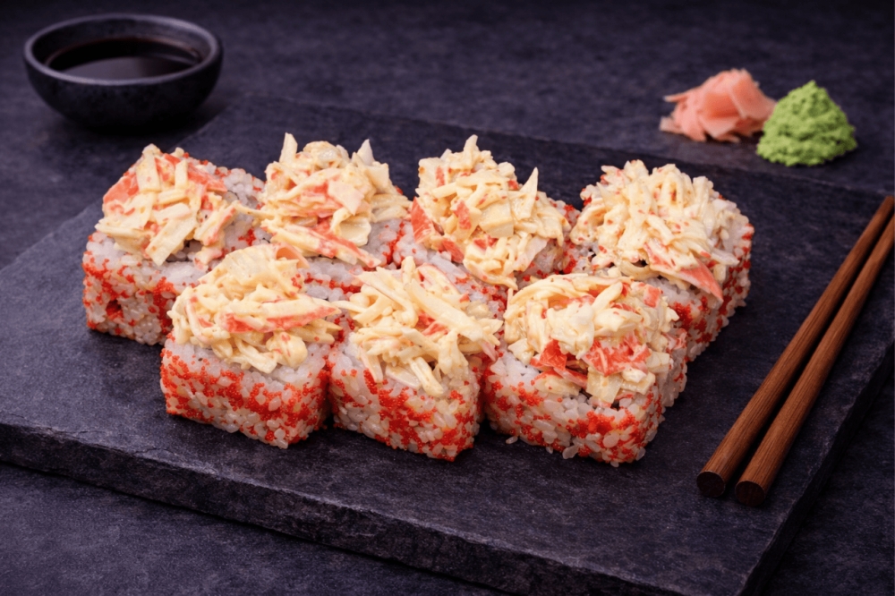 Sushi-rull med rogn, agurk, søt torsk, toppet med surimi og spicy saus
8 biter