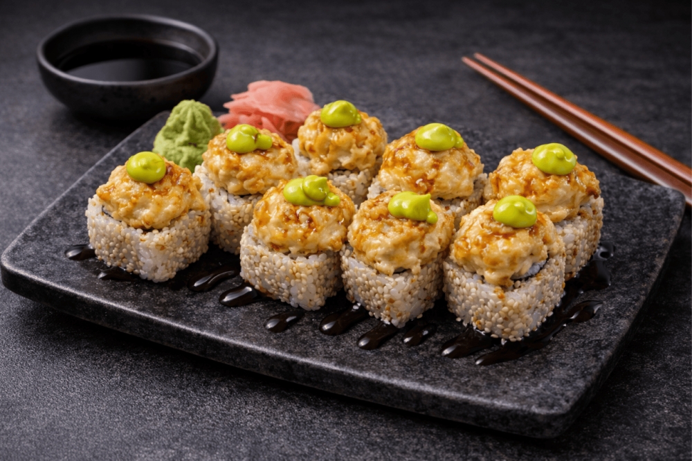 Myk ris rullet i sprø nori, med et hint av ristede sesamfrø. Inni skjuler det seg kremet ferskost og saftig japansk omelett.

På toppen – gyllenstekt kyllingfilet, gratinert med norsk fastost og mild majones. Rullen bakes i ovnen til den blir varm og uimo