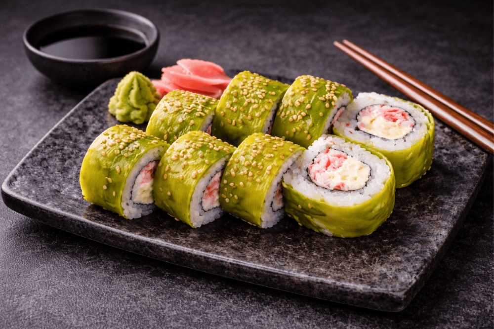 Sushi-rull med surimi og kremost, toppet med avocado, og drizzlet med unagi-saus og sesamfrø
8 biter
